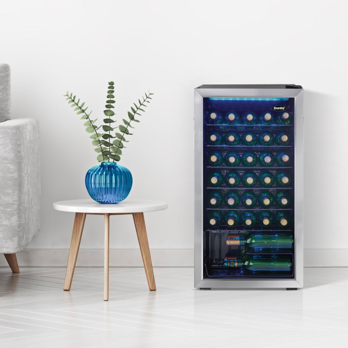 Danby 36 Bottle Freestanding Wine Cooler in Stainless Steel - fridge beside a small white table and blue vase