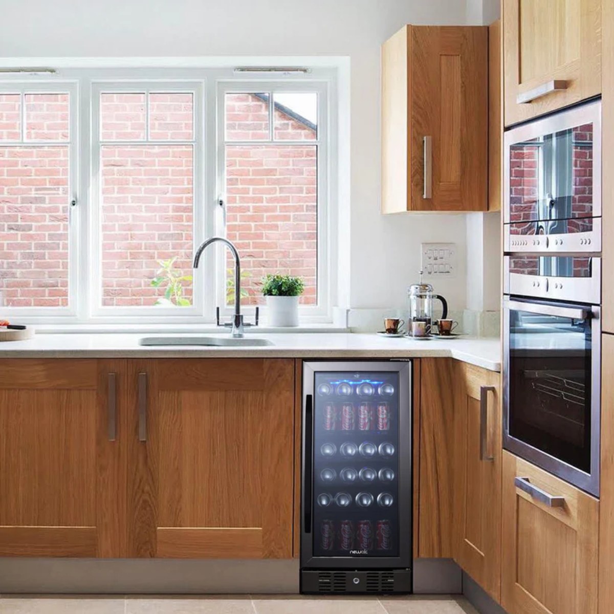 NewAir 15” Built-in 96-Can Beverage Fridge in Black Stainless Steel - beverage fridge in a bright wood-cabinet kitchen