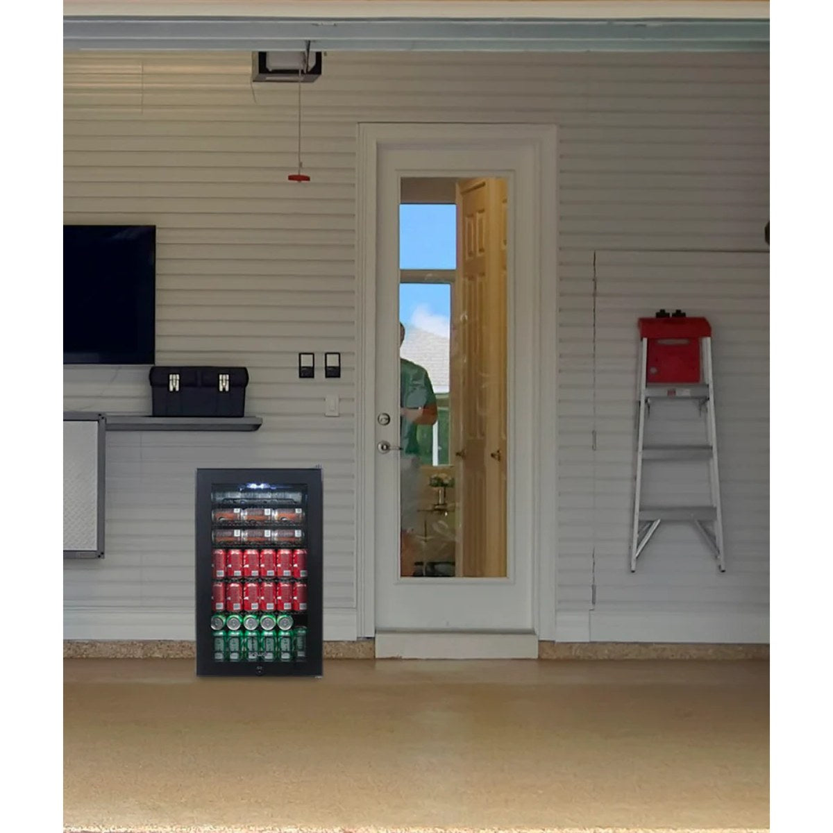 Newair 126-Can Freestanding Beverage Fridge – 19″ Black - fridge placed in a garage environment with tools, ladder, and wall storage in the background