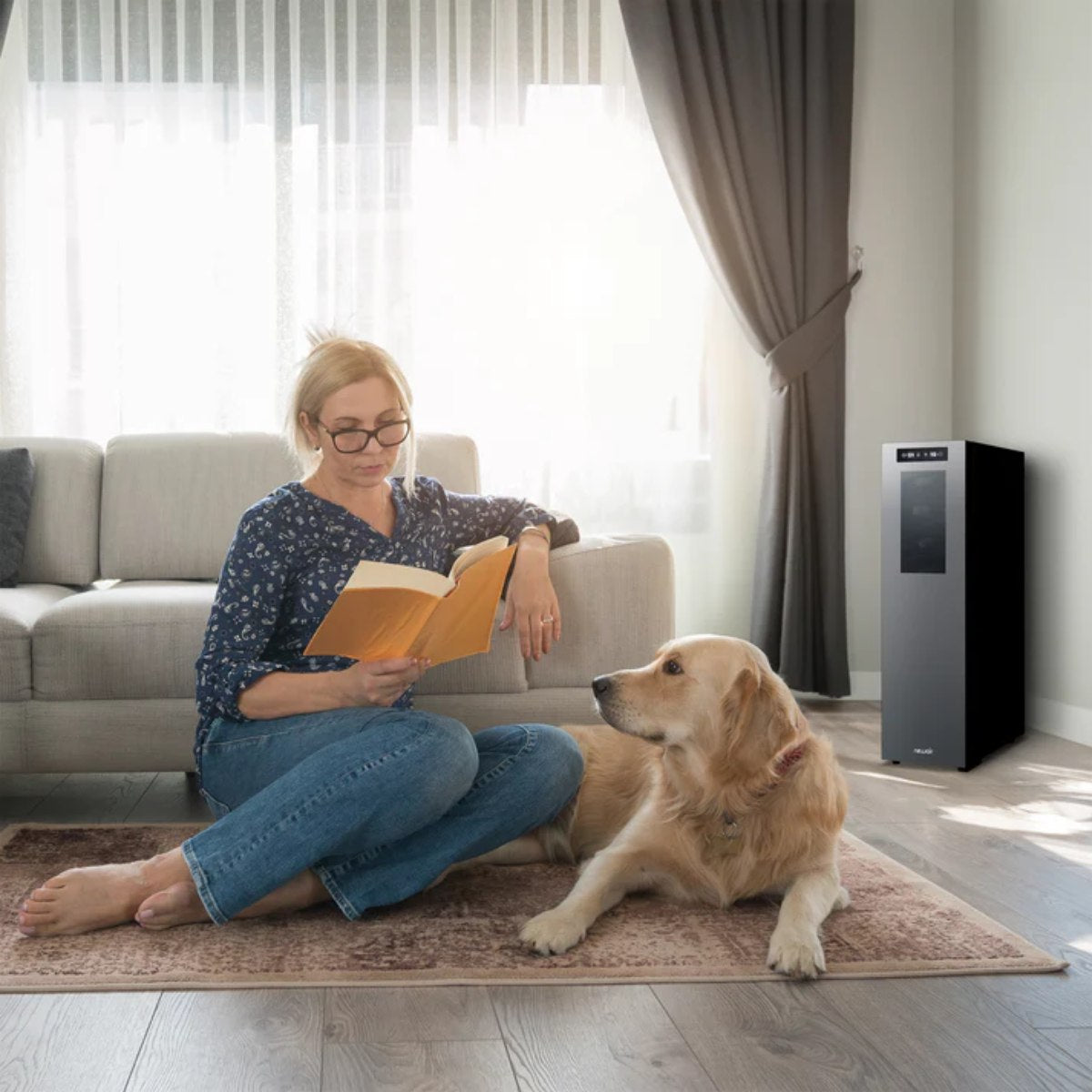 Newair 18 Bottle Shadow-T Series Wine Fridge – 10.75" Black - Woman reading a book on the floor next to her dog in a bright living room with a sleek black Newair wine fridge in the background