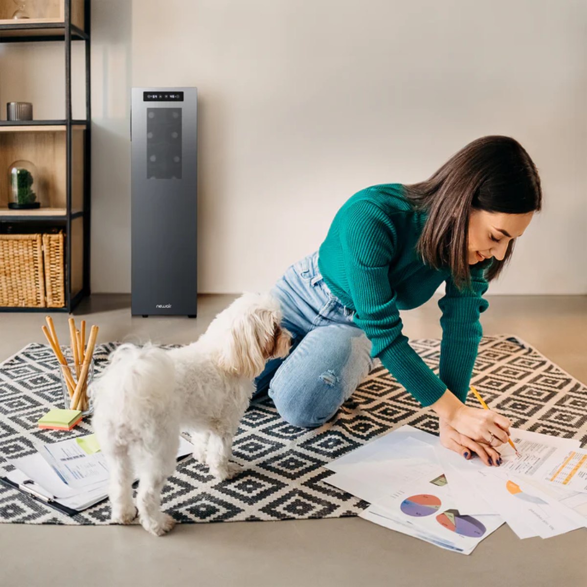 Newair 18 Bottle Shadow-T Series Wine Fridge – 10.75" Black - Woman working on the floor with papers while her dog looks on, with a sleek black Newair wine fridge in the background