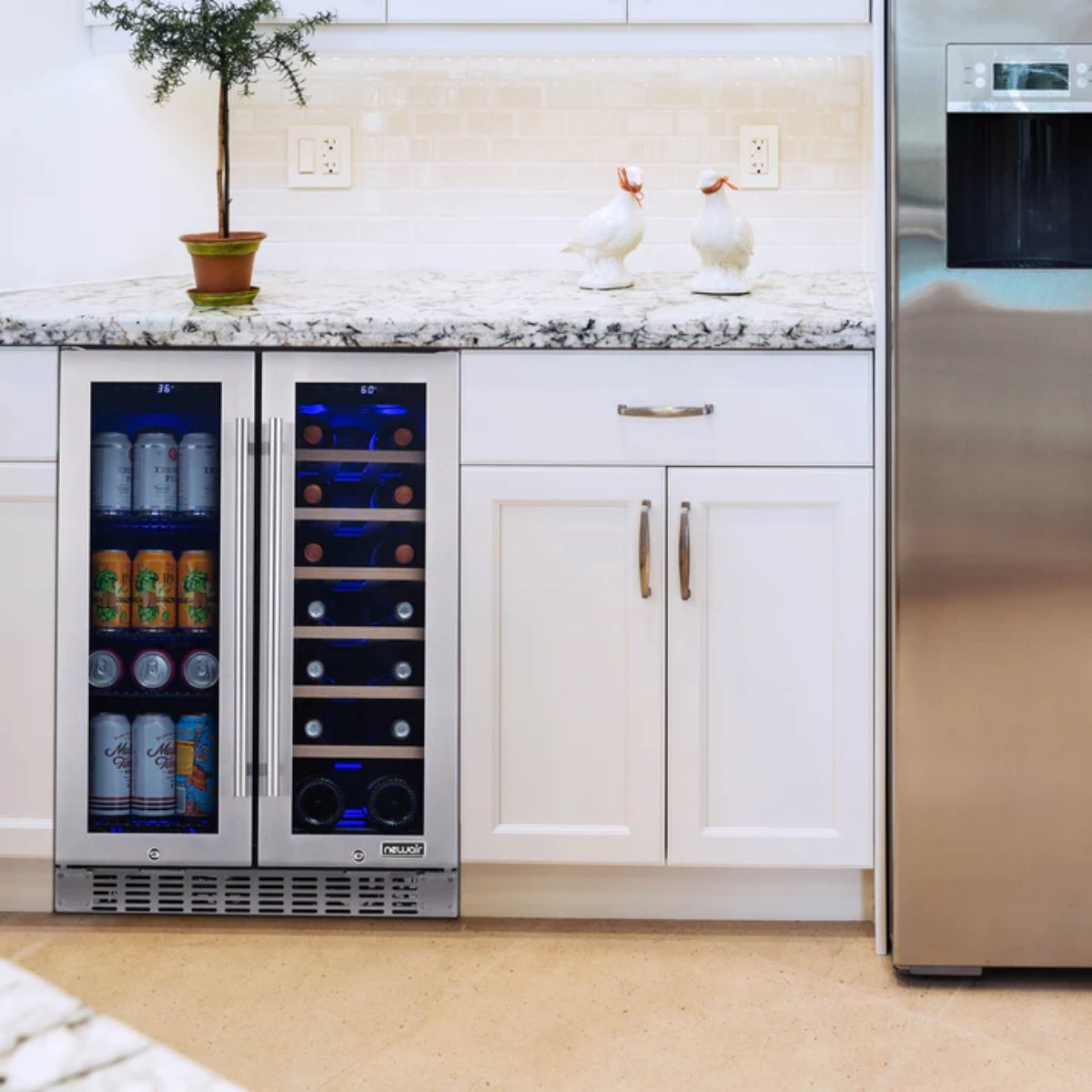 Newair 24″ SplitShelf 58-Can / 18-Bottle Dual Zone Beverage Fridge - fridge installed under a white kitchen counter beside a stainless steel refrigerator