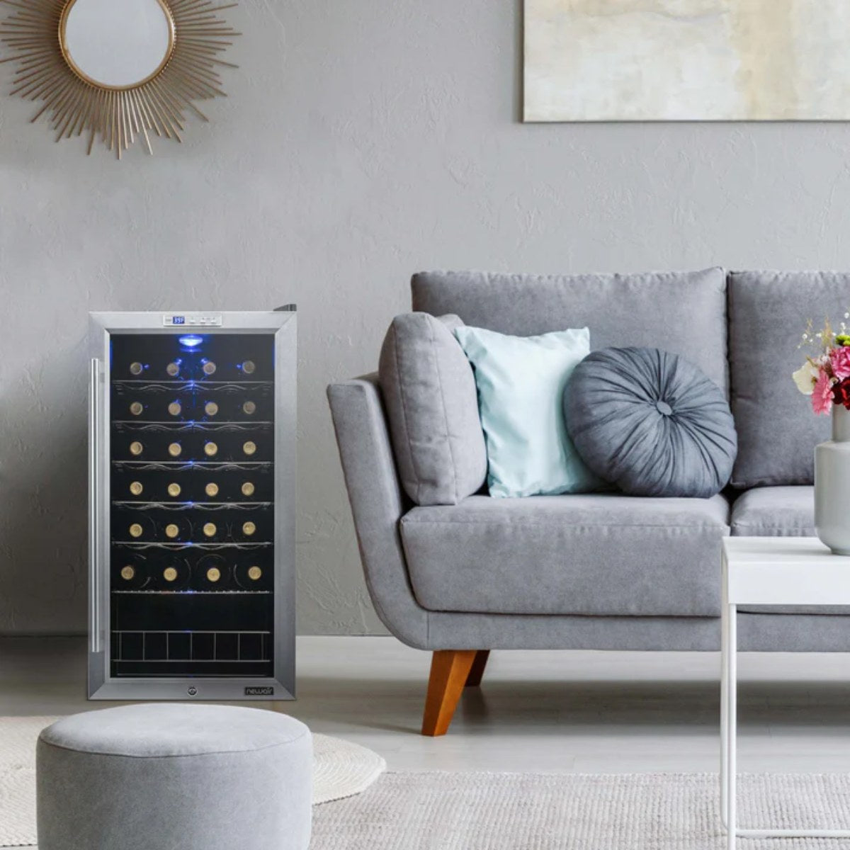 Newair 27 Bottle Freestanding Wine Fridge – 16.9" Stainless Steel - next to a gray sofa in a modern living room