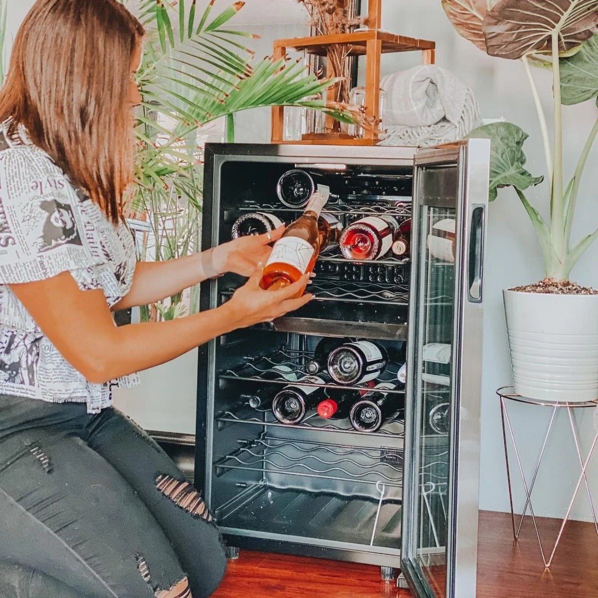 Newair 43 Bottle Dual Zone Wine Fridge – 18.9" Stainless Steel - Woman adding wine to the fridge