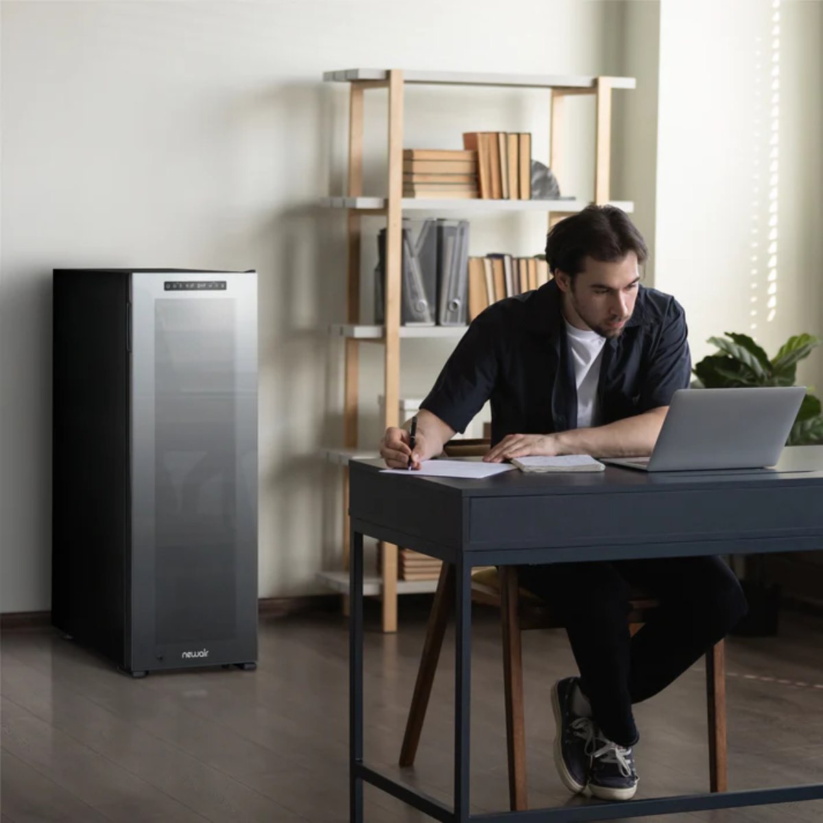 Newair 56 Bottle Shadow Series Dual Zone Wine Fridge – 16.9" Black - Fridge inside the Office room with a man working at the table