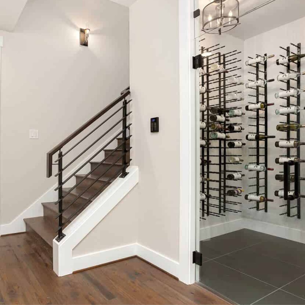 Ultra 3FT Label-Out Horizontal Wall Rail Wine Rack (9–27 Bottles) - Modern wine cellar with glass door beside a staircase featuring sleek metal railing