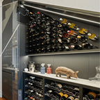 Ultra Cork-Out Straight Wine Peg - Modern wine storage with angled wall-mounted racks, lower cabinets, and decorative display items