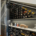Ultra Cork-Out Straight Wine Peg - Modern wine storage with angled wall-mounted racks, lower cabinets, and decorative display items