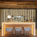 Ultra Floor-To-Ceiling Backer Channel - Elegant home bar with illuminated counter, three stools, and a glass wine wall backdrop