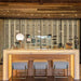 Ultra Floor-to-Ceiling Mounted 1-Sided Wine Rack Display (42 Bottles) - Backlit home bar with three stools and tall vertical wine racks behind glass