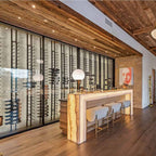 Ultra Floor-to-Ceiling Mounted 1-Sided Wine Rack Display (42 Bottles) - Luxury home bar with glowing counter, stools, and tall glass wine racks