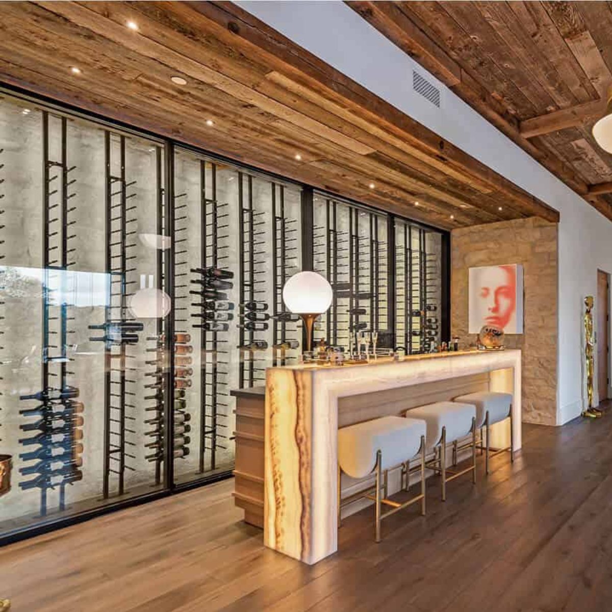 Ultra Floor-to-Ceiling Mounted 1-Sided Wine Rack Display (42 Bottles) - Luxury home bar with glowing counter, stools, and tall glass wine racks