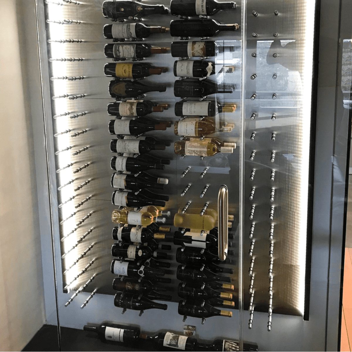 Ultra Fusion Panel Wine Rack – Alumasteel Label-Out - Glass-enclosed wine rack with backlit metal pegs displaying bottles horizontally