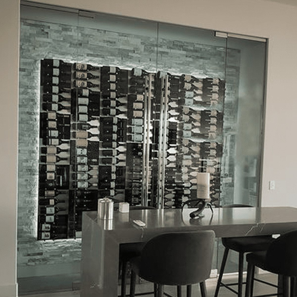 Ultra Fusion Panel Wine Rack – Black Acrylic Label-Out - Modern glass-enclosed wine cellar with backlit stone wall and dining area in front