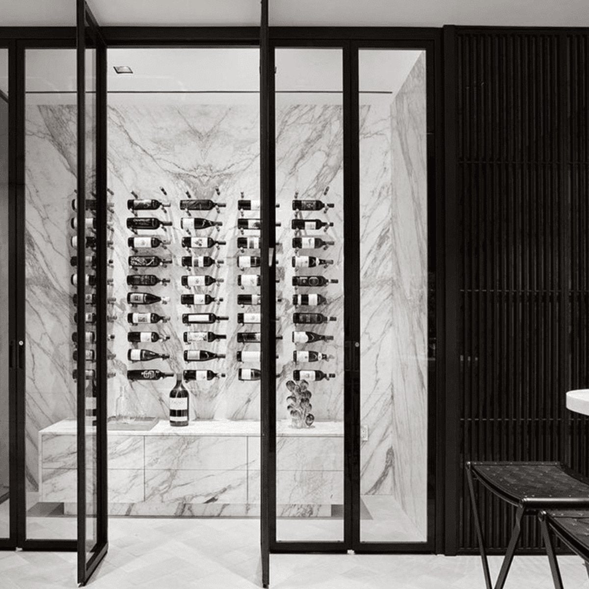 Ultra Label-Out Horizontal Wine Pegs - Glass-enclosed wine cellar with marble walls and wall-mounted bottle racks