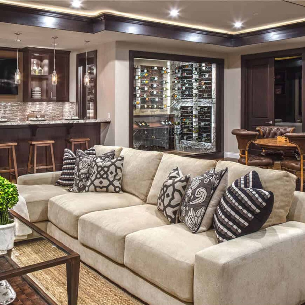 Ultra Label-Out Horizontal Wine Pegs - Modern living room with beige sectional sofa, bar area, and glass-enclosed wine cellar