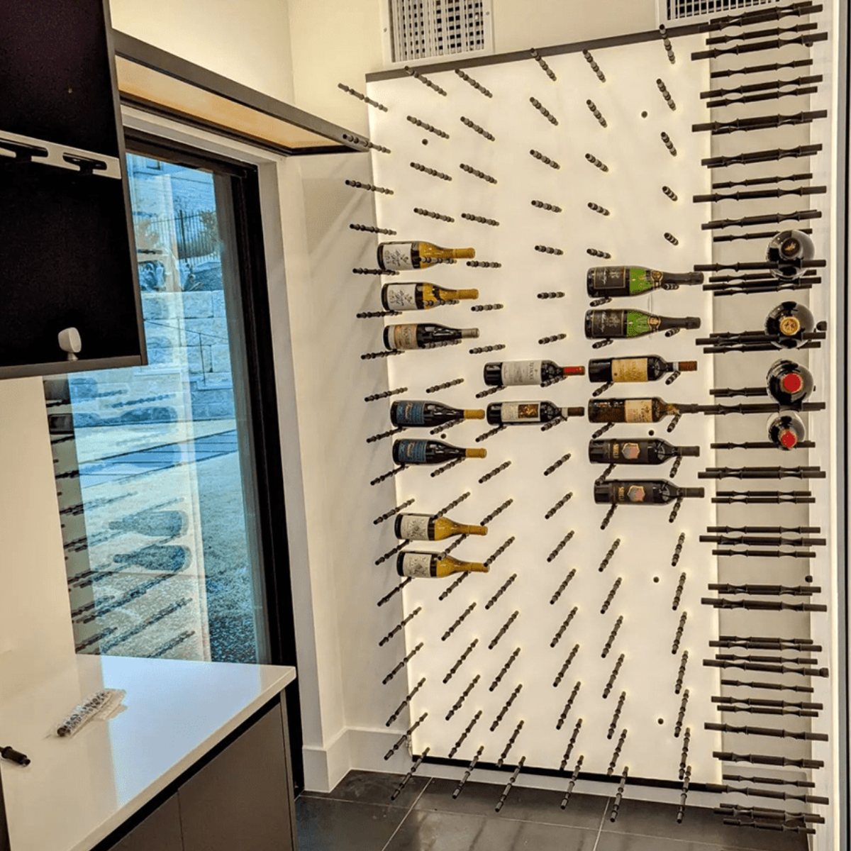 Ultra Label-Out Horizontal Wine Pegs - Wine wall with modern black metal racks and a mix of displayed bottles