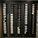 VintageView 2 Foot wall mounted wine storage rack installed behind glass with label forward bottle display in a custom cellar wall