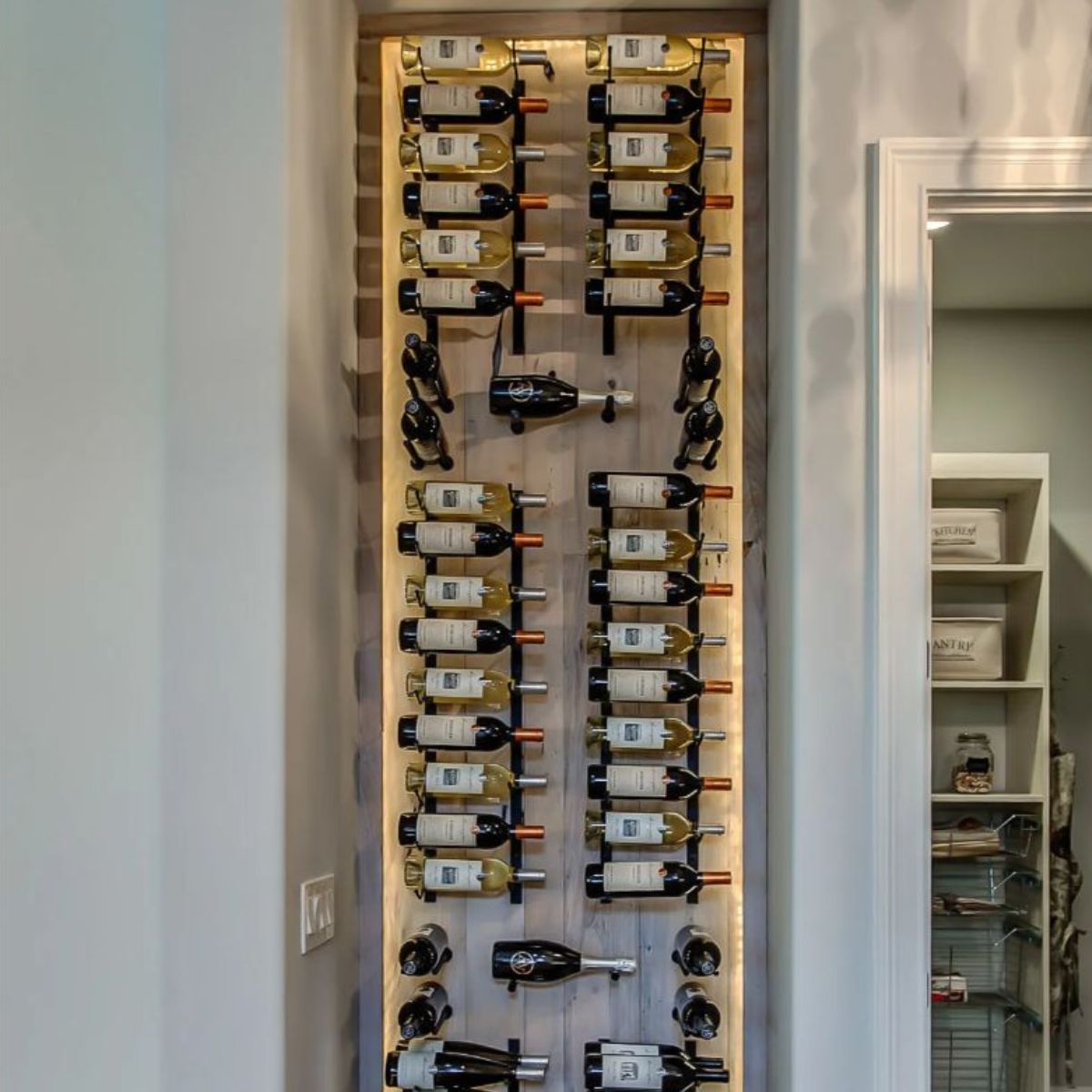 VintageView 3 Foot wall mounted wine rack installed on a backlit wood panel showcasing label forward wine bottle storage