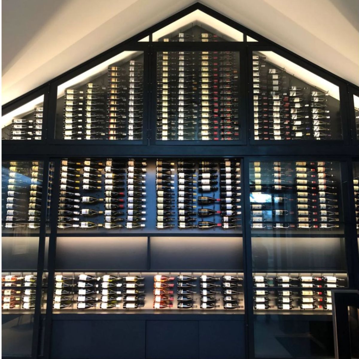 VintageView 4 Foot wall mounted wine storage rack installed in a gabled glass enclosed wine room with label forward storage