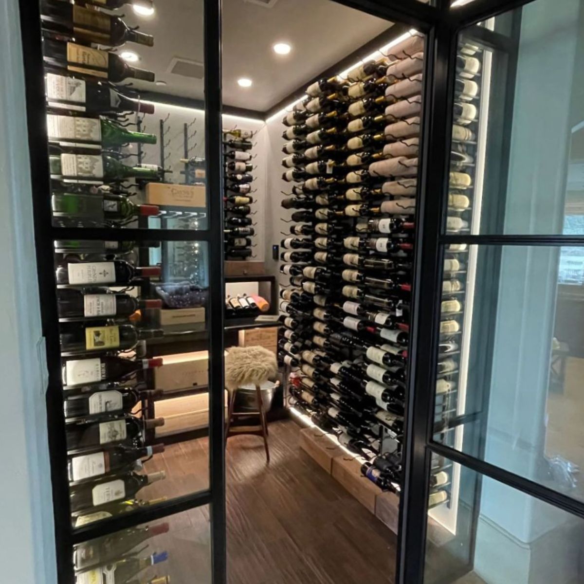 VintageView 4 Foot wall mounted wine storage rack installed inside a modern glass door wine cellar with label forward bottle storage