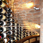 VintageView 4 inch wall mounted metal wine rack mounted on a stone wall with multi row horizontal wine bottle storage