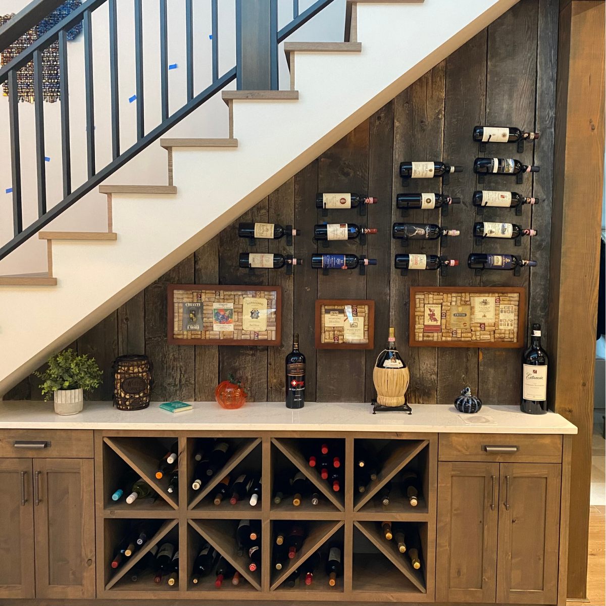 VintageView 4 inch wall mounted metal wine rack installed under a staircase creating a compact residential wine display
