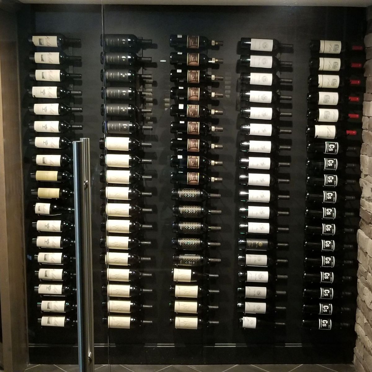 VintageView 5 Foot wall mounted wine rack displayed on a black feature wall with multi column label forward wine storage