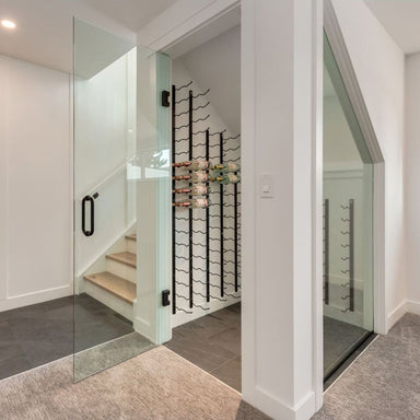 VintageView 5 Foot wall mounted wine rack installed under stairs inside a glass enclosure with compact wine bottle display