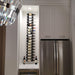 VintageView 6 Foot wall mounted wine storage rack installed in a kitchen niche beside cabinetry with vertical label forward wine storage