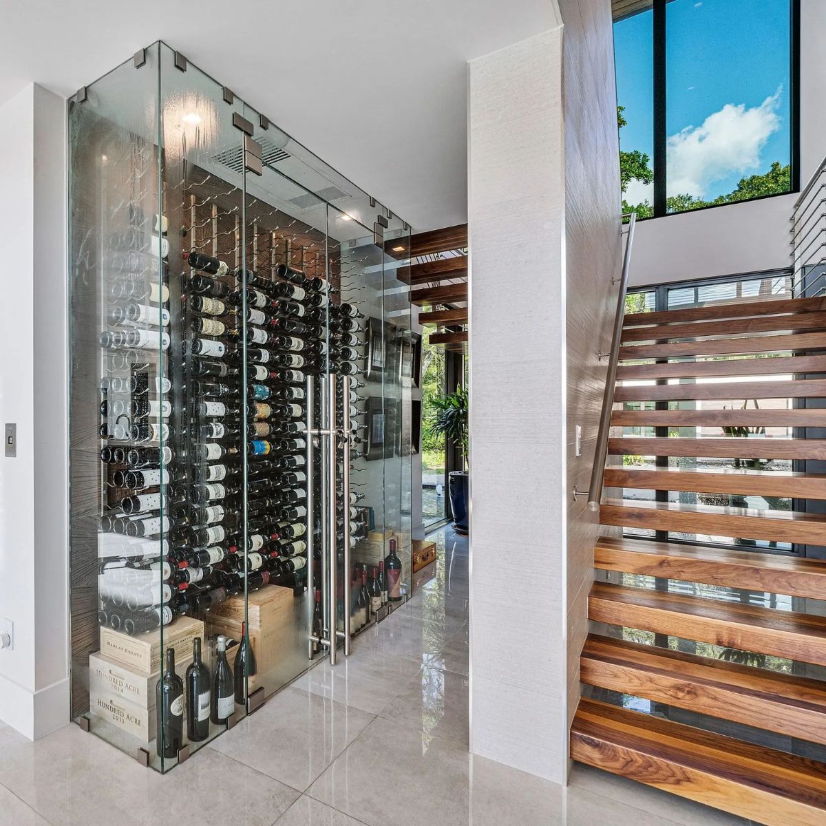 VintageView 7 Foot wall mounted wine storage rack installed in a glass enclosed staircase wine cellar with label forward bottle display