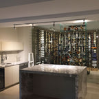 VintageView 8 Foot wall mounted wine storage rack used as a feature wall behind a luxury bar and kitchen island with glass enclosure