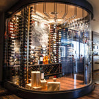 VintageView Big Bottle wall mounted wine racks inside a curved glass wine cellar