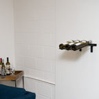 VintageView Presentation Row wall mounted wine rack in a minimalist home interior holding three horizontal wine bottles