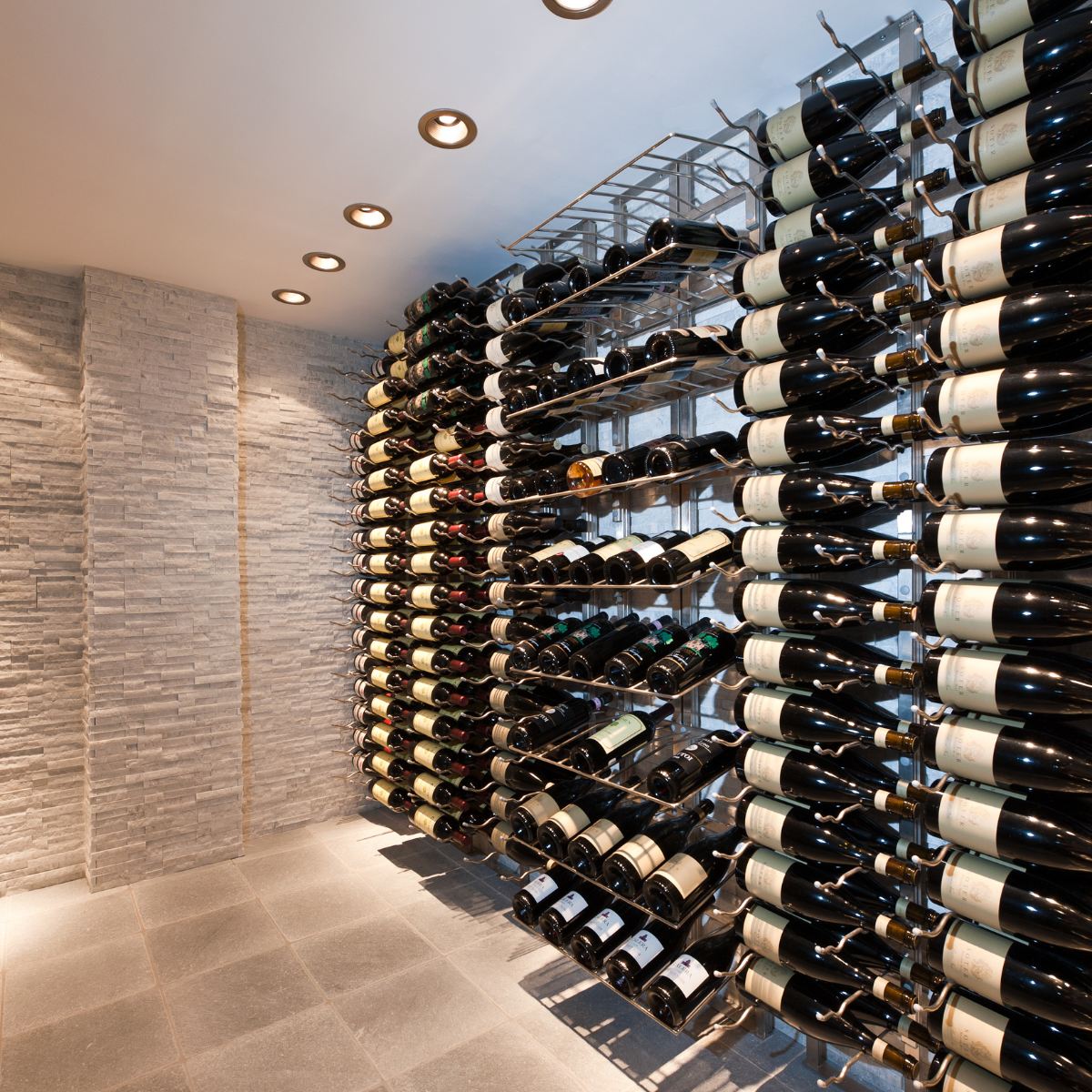 VintageView Presentation Row wall-mounted wine rack displayed in a contemporary stone wine room
