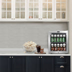Whynter BR-062WS 68-Can Stainless Steel Beverage Refrigerator - fridge filled with soda cans on a kitchen counter beside popcorn and a drink