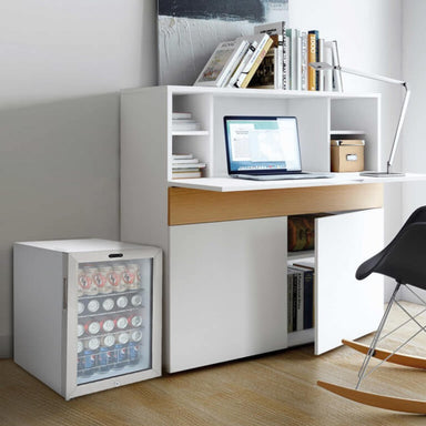 Whynter BR-091WS 90-Can Stainless Steel Beverage Refrigerator - filled with soda cans beside a modern white home office desk
