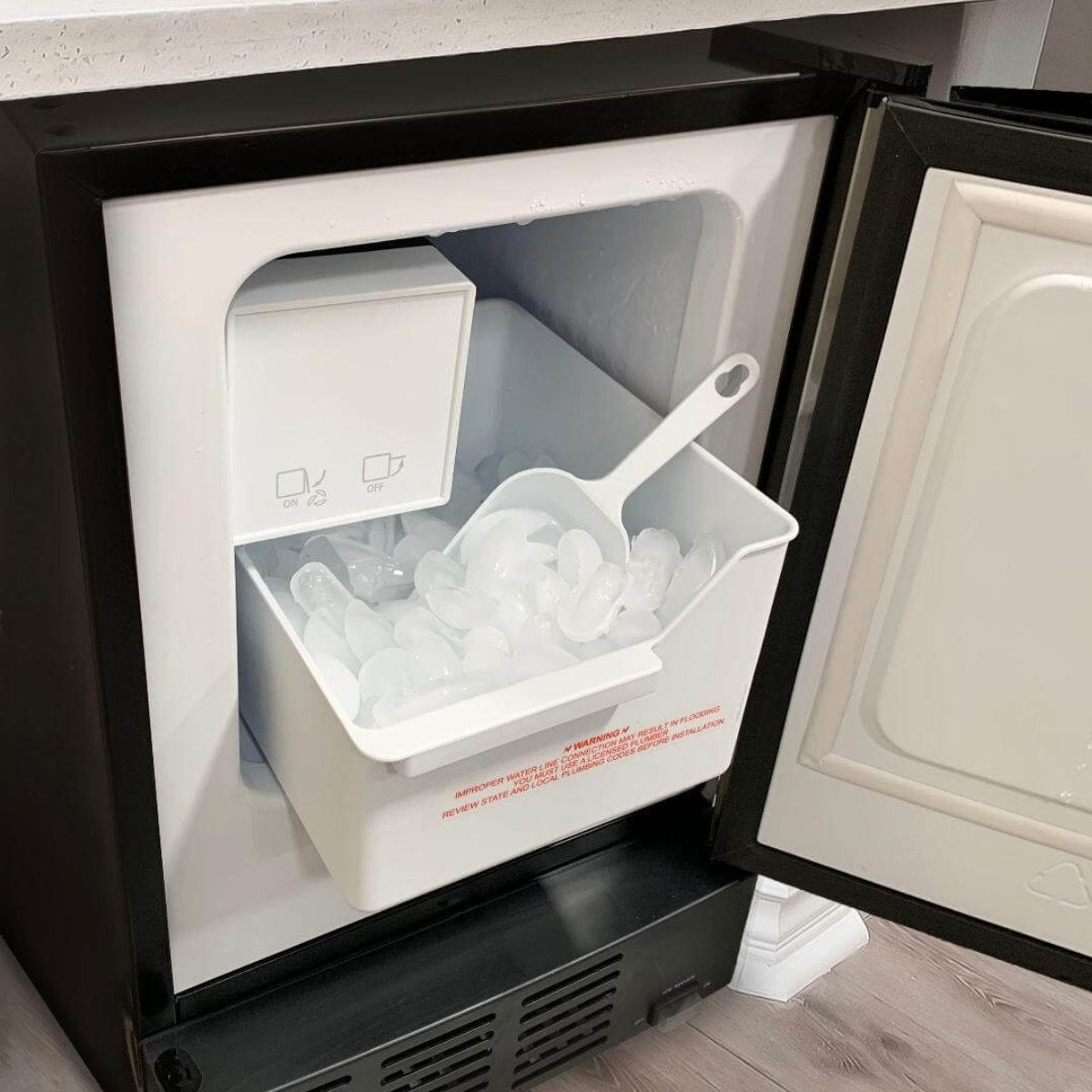 Whynter UIM-155 15" Stainless Steel Built-In Ice Maker - showing ice bin filled with clear crescent-shaped ice cubes and scoop